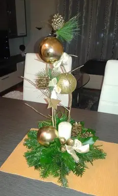 a christmas centerpiece with balls and greenery on a table at Omega in Doboj