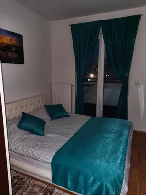 a bedroom with a bed with blue pillows and a window at Omega in Doboj