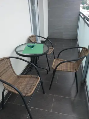 three chairs and a table on a balcony at Omega in Doboj