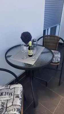 a glass table with two bottles and glasses on it at Omega in Doboj