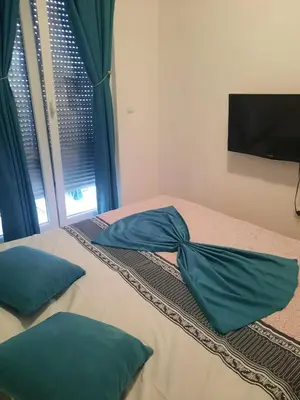 a bed with two pillows on it with a window at Omega in Doboj