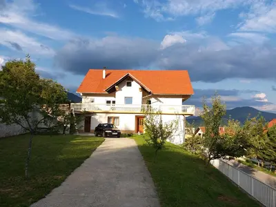 a white house with an orange roof and a driveway at Kuca za odmor Sarcevic in Prozor