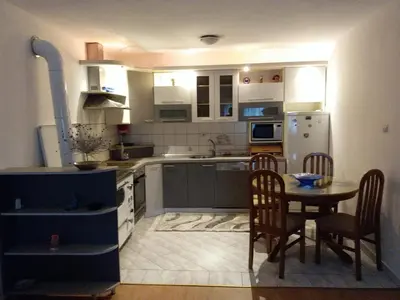 a small kitchen with a table and a refrigerator at Kuca za odmor Sarcevic in Prozor