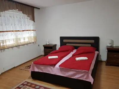 a bedroom with a bed with red pillows on it at Prenociste Sana Sanski Most in Sanski most