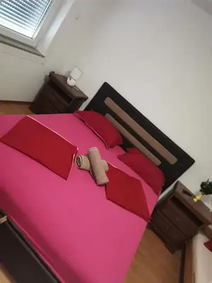 a bedroom with a pink bed with a teddy bear on it at Prenociste Sana Sanski Most in Sanski most