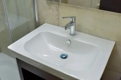 a white sink in a bathroom with a mirror at Motel Grand in Velika Kladuša