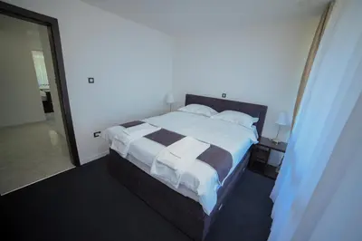 a bedroom with a large bed with white blankets and pillows at Motel Grand in Velika Kladuša
