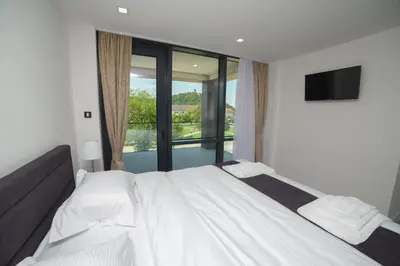 a bedroom with a large white bed and a window at Motel Grand in Velika Kladuša