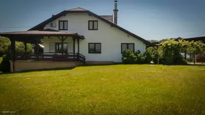 a white house with a grassy yard in front of it at Green Forest Visoko in Visoko