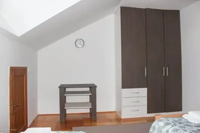 a bedroom with a wooden cabinet and a table at Green Forest Visoko in Visoko