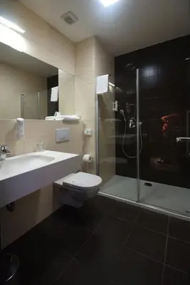 a bathroom with a toilet and a sink and a shower at Hotel Park Doboj in Doboj