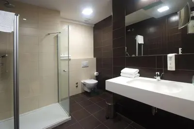 a bathroom with a sink and a shower and a toilet at Hotel Park Doboj in Doboj
