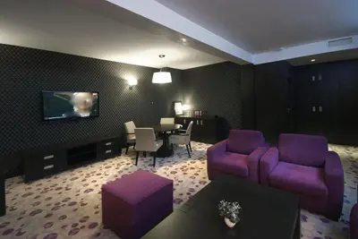 a living room with a purple couch and a table at Hotel Park Doboj in Doboj
