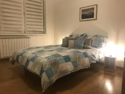 a bedroom with a bed with a quilt and a lamp at Apartment Galerija in Tuzla