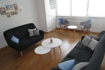 a living room with a couch and tables and chairs at Apartment Galerija in Tuzla