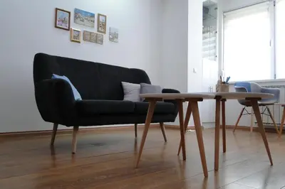 a living room with a couch and a wooden table at Apartment Galerija in Tuzla