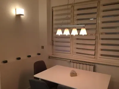 a dining room with a table and chairs and a window at Apartment Galerija in Tuzla