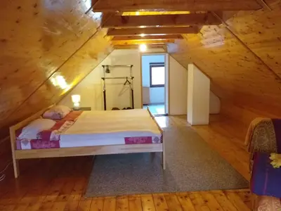 a bedroom with a large bed in a attic at Una holiday house in Bihać