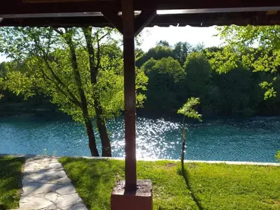 a pole in the grass near a body of water at Una holiday house in Bihać
