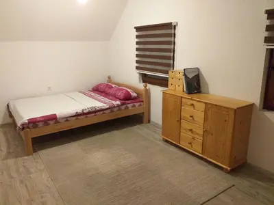 a small bedroom with a bed and a wooden dresser at Una holiday house in Bihać
