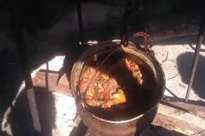 a pot of food is cooking in an oven at Una holiday house in Bihać