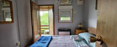 a bedroom with a bed and a door with a window at Green Oasis in Bihać