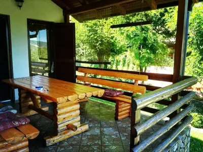 a wooden table and bench on a patio at Green Oasis in Bihać