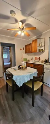 a kitchen with a table and a ceiling fan at Green Oasis in Bihać