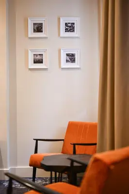 a room with a chair and pictures on the wall at Hotel Ideja in Banja Luka
