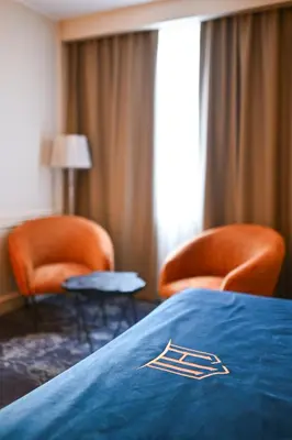 a hotel room with two chairs and a bed at Hotel Ideja in Banja Luka