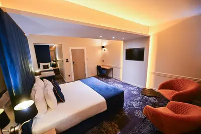 a hotel room with a bed and two chairs at Hotel Ideja in Banja Luka