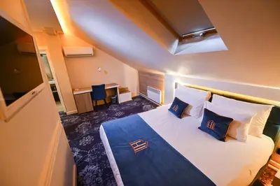 a hotel room with a bed with blue and white pillows at Hotel Ideja in Banja Luka