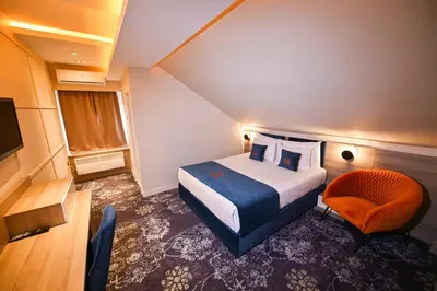 a hotel room with a bed and a chair at Hotel Ideja in Banja Luka