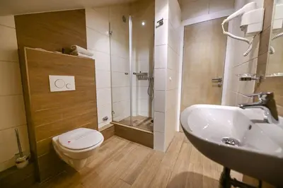 a bathroom with a toilet and a sink and a shower at Hotel Ideja in Banja Luka