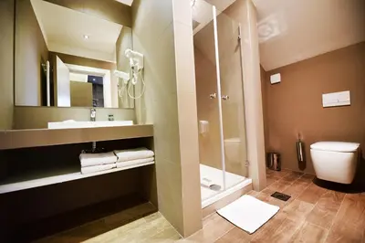a bathroom with a shower and a sink and a toilet at Hotel Ideja in Banja Luka