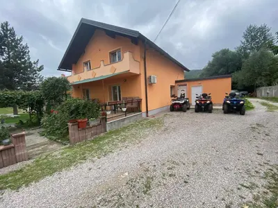 a house with two motorcycles parked in front of it at Vila Una 1 in Ripač