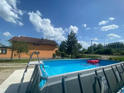 a swimming pool in front of a house at Vila Una 1 in Ripač