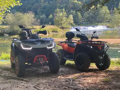 two atvs and a atv and a quad bike parked by a river at Vila Una 1 in Ripač