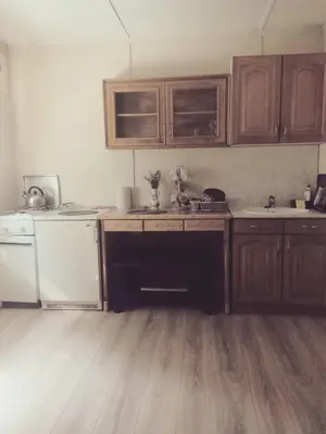 a kitchen with wooden cabinets and a wooden floor at Sunny Paradise in Bihać
