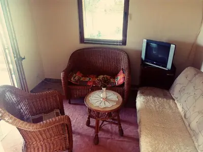 a living room with wicker chairs and a table and a tv at Sunny Paradise in Bihać