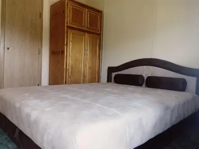 a bedroom with a bed and a wooden cabinet at Sunny Paradise in Bihać
