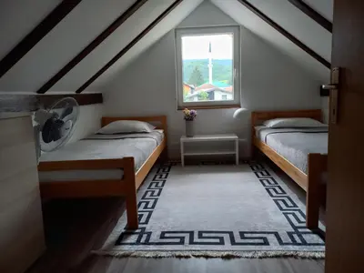 a attic room with two beds and a window at Vacation Home 