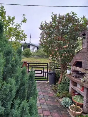 a garden with a fence and a tree and a brick walkway at Vacation Home 