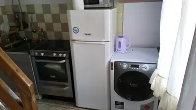 a small kitchen with a refrigerator and a microwave at Cottage Forest Stream in Visoko