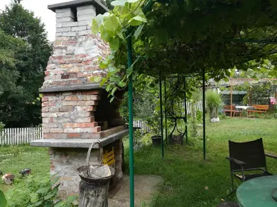 a brick oven in a garden with a table at Cottage Forest Stream in Visoko