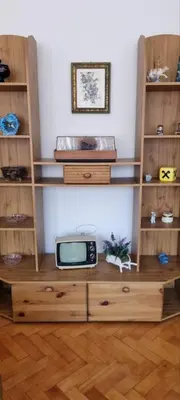 a wooden book shelf with a tv on it at Trosoban stan u Zenici in Zenica