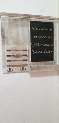 a sign on a wall that says welcome banquetinatorsphoneodaodaost at Trosoban stan u Zenici in Zenica