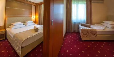 a hotel room with two beds and a window at Hotel Cezar Banja Luka in Banja Luka