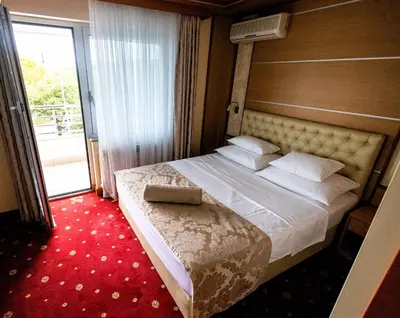 a bedroom with a large bed with a large window at Hotel Cezar Banja Luka in Banja Luka