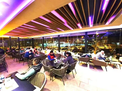 a group of people sitting at tables in a restaurant at Hotel Cezar Banja Luka in Banja Luka